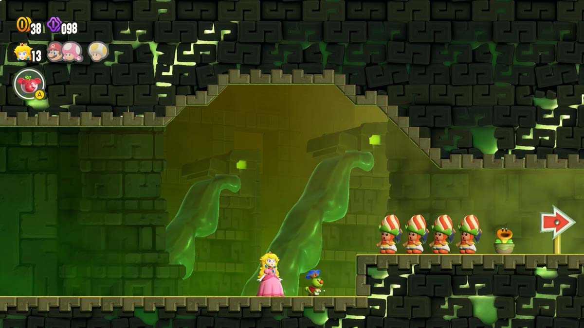 超级马罗兄弟神奇公主桃子和一群戴着防护头盔的角色在幽灵般的绿色城堡走廊中朝箭头指示的方向看去。